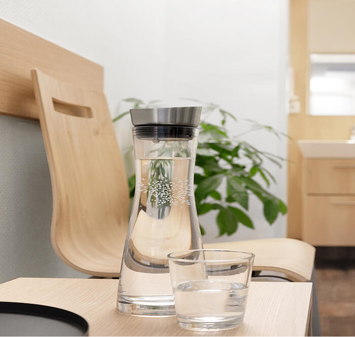 Holzstühle im Wartebereich, Getränke stehen zur Verfügung